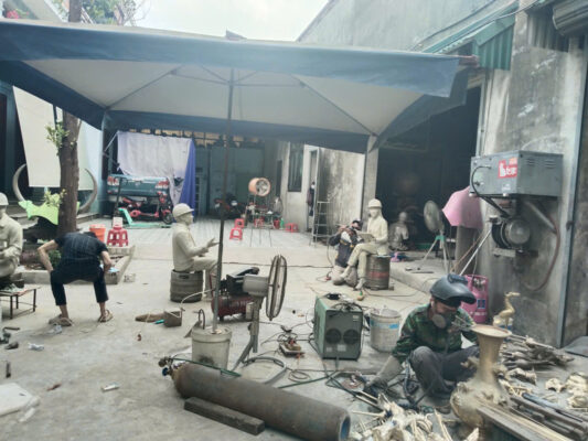 Nghệ nhân và kỹ thuật viên trực tiếp gia công, tinh chỉnh phôi tượng người xây dựng tại xưởng sản xuất
